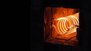 A potter loading bisque ware into an electric kiln in a studio
